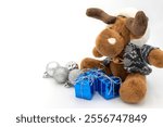 Stuffed reindeer toy, with gift boxes and some Christmas decoration.