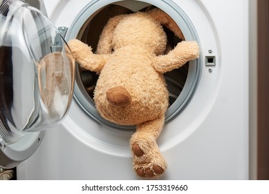 Stuffed Toy Rabbit With His Back In The Washing Machine.