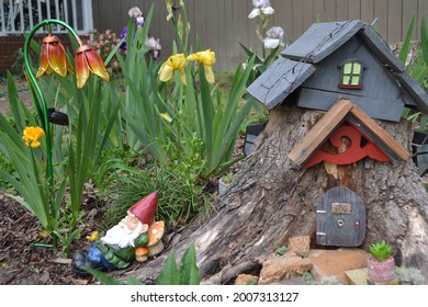 Stump gnome home in the flower garden