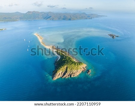 Stunning aerial high angle view of Langford Island with a long spit and Hook Island in the background, both part of the Whitsunday Islands group near the Great Barrier Reef in Queensland, Australia.
