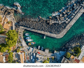 Stunning aerial shot of San Giovanni li Cuti, a charming neighborhood in Catania overlooking the sea. The image features a bird's eye view of the picturesque harbor