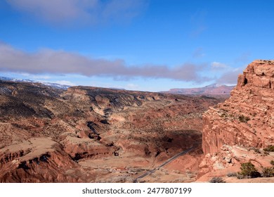 Stunning aerial view of Capitol Reef National Park in Utah, showcasing expansive red rock formations, rugged terrain, and a bright blue sky - Fruita District, USA - Powered by Shutterstock