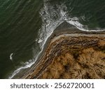 A stunning aerial view capturing the rugged West Coast shoreline, with scattered driftwood, ocean waves meeting the rocky coast, and wild beauty of Vancouver Island, British Columbia.