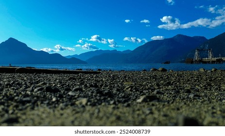 A stunning aerial view of a coastal landscape featuring a beach with rocky outcrops in the foreground and a boat docked in the distance - Powered by Shutterstock