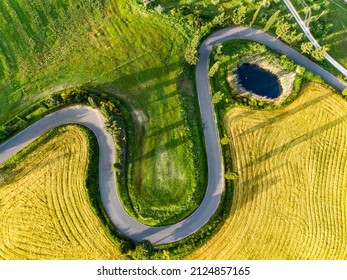 Stunning aerial view of green fields and farmlands. Summer rural landscape of rolling hills, curved roads and cypresses of Tuscany, Italy.