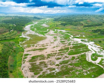 A stunning aerial view of a meandering river cutting through lush green landscapes and agricultural fields in Burundi, under a dramatic cloudy sky, highlighting the natural beauty of the region.
 - Powered by Shutterstock