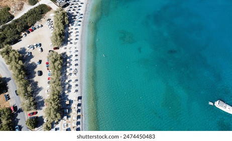 Stunning aerial view of Plaka Beach in Crete,  with the view of Spinalonga showcasing the vibrant turquoise waters, a serene sailboat, rocky cliffs, and whitewashed houses nestled along the coastline - Powered by Shutterstock