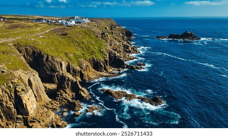 A stunning aerial view of a rugged coastline with cliffs, lush green hills, and the deep blue ocean. At Land's End, Cornwall, UK. - Powered by Shutterstock