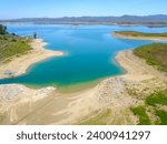 a stunning aerial view of the still blue waters of Lake Mathews in the Cajalco Canyon in the foothills with mountain ranges and blue sky in Perris California USA	