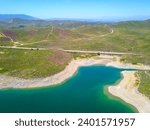 a stunning aerial view of the still blue waters of Lake Mathews in the Cajalco Canyon in the foothills with mountain ranges and blue sky in Perris California USA	