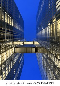 Stunning Architectural View from Below of Two Glass Buildings Against a Vibrant Blue Sky
