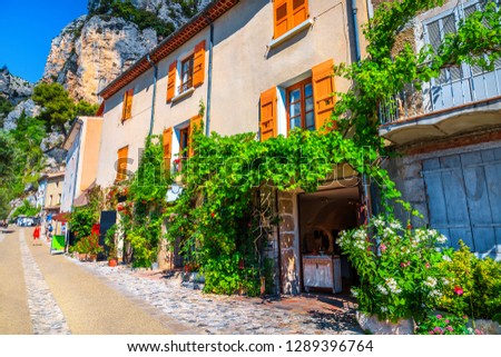Stunning best village travel destination in Provence. Cute traditional Provence houses, decorated street with amazing mediterranean flowers, Moustiers-Sainte-Marie, Provence, France, Europe