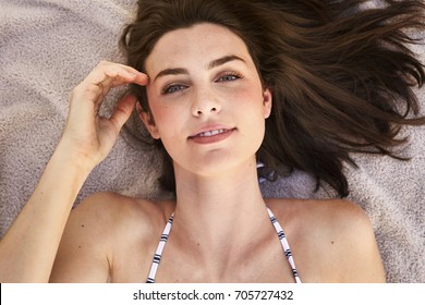 Stunning bikini babe lying down relaxing, portrait