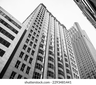 A stunning black and white photograph of a towering office building in an urban downtown metropolis, captured from a low angle view. - Shutterstock ID 2293481441