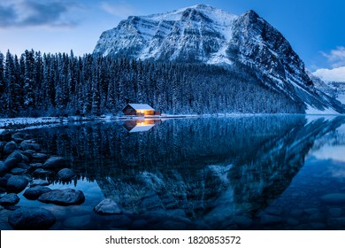 Stunning blue hour shot of a boat house on a crystal clear winter morning at Lake Louise, Alberta, Canada 