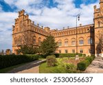 Stunning brick architecture of the historic residence with ornate details, surrounded by manicured gardens. The building showcases a blend of Byzantine and Moorish styles under a cloudy sky