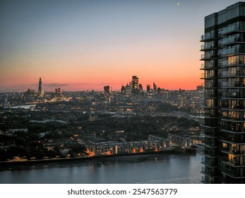 A stunning cityscape of London at sunset featuring the Shard and city skyline with a crescent moon in the sky. - Powered by Shutterstock