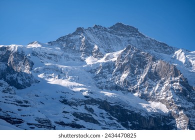 Stunning close up view of Eiger north face from Kleine Scheidegg on a winter sunny day, famous mountain of Swiss Alps on Bernese Oberland near Jungfrau, Interlaken, Switzerland