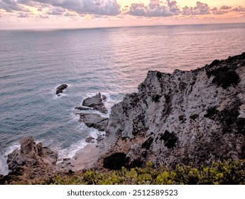 A stunning coastal cliff view overlooking calm ocean waters at sunset. Rugged cliffs and serene beach offer a perfect backdrop for travel, nature, or outdoor adventure themes. - Powered by Shutterstock