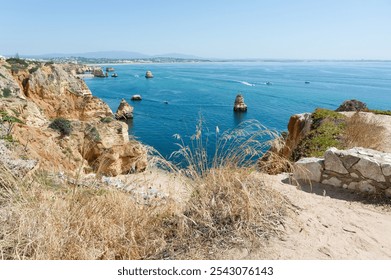 Stunning coastal cliffs overlooking the azure waters of Lagos, with boats gliding past iconic rock formations in a serene seascape. - Powered by Shutterstock