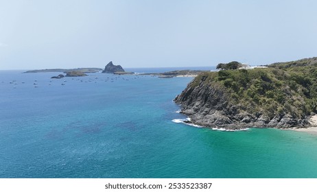 A stunning coastal landscape featuring clear turquoise waters, rocky cliffs, and distant islands under a bright blue sky. - Powered by Shutterstock