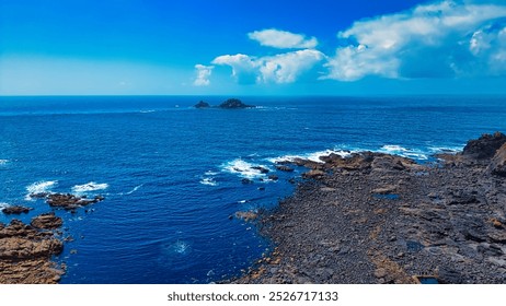 A stunning coastal view featuring a rocky shoreline and clear blue ocean waters. At Land's End, Cornwall, UK - Powered by Shutterstock