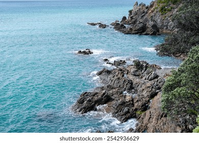 Stunning coastal view showcasing a rocky shoreline and vibrant turquoise water. This serene landscape invites relaxation and appreciation of nature's beauty by the sea. - Powered by Shutterstock