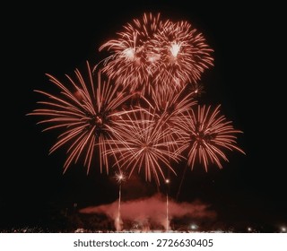 A stunning display of red fireworks exploding in the night sky, creating a mesmerizing spectacle with bursts of light and color.