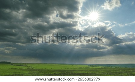 A Stunning and Dramatic Sky Displayed with Sunbeams Over a Vibrant Green Landscape Time lapse.