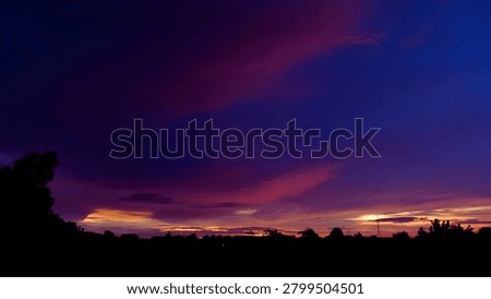 Stunning dramatic twilight sky with vibrant purple, magenta, and deep blue clouds at sunset.