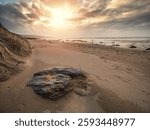Stunning Fanore beach in county Clare, Ireland. Popular travel and tourist hotspot with amazing Irish nature scenery view. Sandy beach with rocks, powerful ocean with waves and dramatic sky.