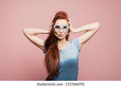 Stunning Female Model Posing With Joy Face Expression On Pink Background. Portrait Of Surprised Young Woman In Sunglasses Jumping In Front Of Pink Wall