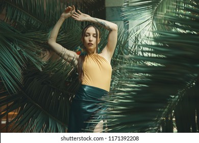 Stunning fit woman among tropical plants. Beauty, fashion. Spa, healthcare. Tropical vacation. Dancing