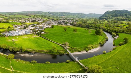 A stunning high-angle multi image panorama capturing the elegant Pont Gower suspension bridge as it spans the winding River Conwy showcasing the peaceful rural charm of North Wales near Llanrwst.