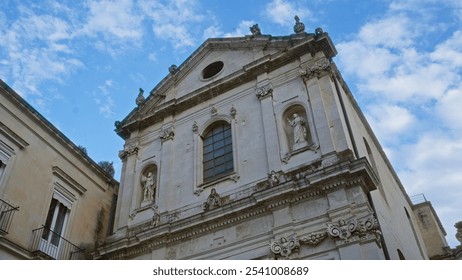 A stunning historical building facade with intricate stone carvings and statues under a bright blue sky in lecce, puglia, italy, showcasing european architectural beauty. - Powered by Shutterstock