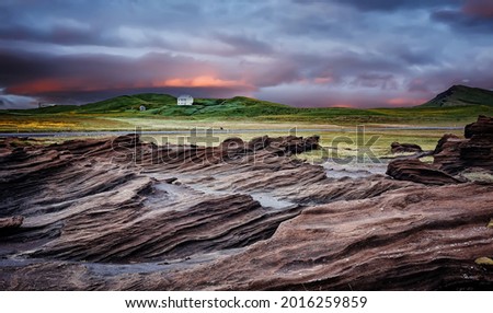 Stunning Iceland nature landscape.  Scenic Image of Iceland during sunset. Red sandy Volcanic rock formation near Dyrholaey coast of Iceland, Europe. Typical Icelandic scenery in a cloudy day.