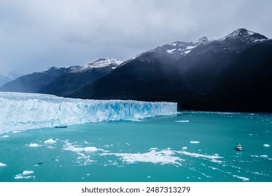 A stunning icy landscape featuring a massive glacier meeting turquoise waters, with snow-capped mountains in the background under a cloudy sky. - Powered by Shutterstock
