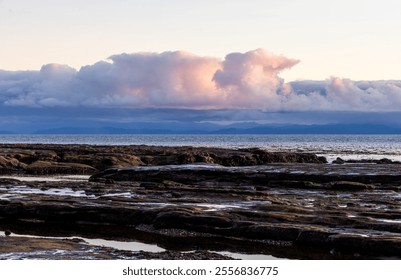 Stunning image of dramatic clouds illuminated by sunset light over the rocky coastline of Port Renfrew, Vancouver Island. Tranquil ocean scenes create a sense of peaceful solitude and natural beauty. - Powered by Shutterstock