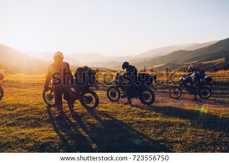 Stunning image of the group of bikers in the evening light. Picturesque and dramatic scene. Location Carpathians, Ukraine, Europe. Warm tone. Explore the world's beauty. Concept active extreme rest.