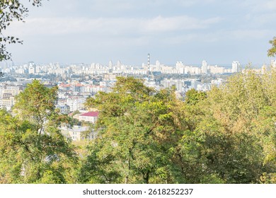 A stunning image showcasing a panoramic view of a city from atop a hill, with verdant trees and modern skyscrapers coexisting harmoniously
