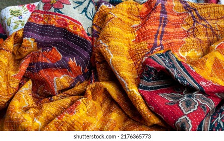 Stunning Indian patchwork quilt in warm red, orange and yellow colours with the traditional Kantha running stitch embroidered from top to bottom - Shutterstock ID 2176365773