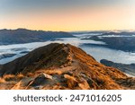 Stunning landscape of sunrise shine over Roys Peak summit and foggy mountain over Lake Wanaka in autumn at New Zealand