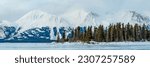 Stunning landscape views from the small town of Atlin in British Columbia during winter season with snow capped mountains in panoramic view. Huge frozen lake with spectacular arctic scenery.