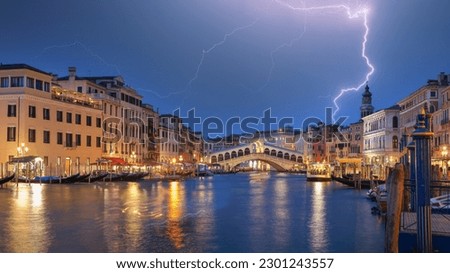 Stunning lightning at night sky over city of f Venice with famous Canal Grande and Rialto Bridge. Popular travell destination. Location: Venice, Veneto region, Italy, Europe
