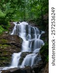 A stunning long exposure photograph of Shypit Waterfall in the Carpathian Mountains of Ukraine. The long exposure technique creates a smooth, silky effect on the cascading water
