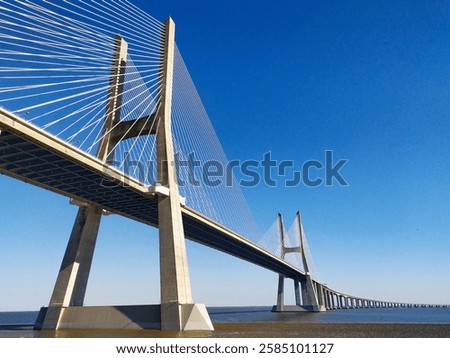 Stunning lowangle view of a cablestayed bridge against a vibrant blue sky.  Perfect for architecture, engineering, travel, and transportation projects.