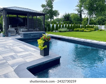 Stunning luxury backyard view of pool with sundeck, chaise lounges, garden, pergola   Modern and sleek, it has an effortless boho inspired, resort like feel. Inspired by Tulum, Mexico's summer vibes. - Powered by Shutterstock