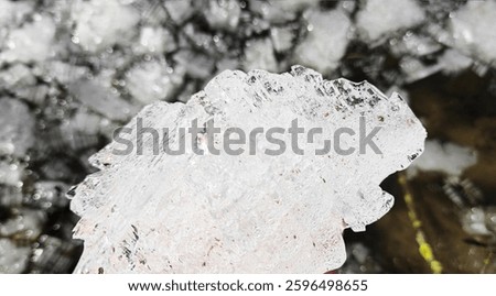 A stunning macro shot of a translucent ice crystal fragment, showcasing intricate frozen patterns and natural winter beauty