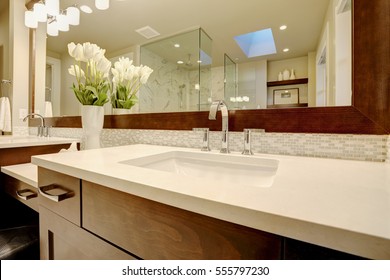 Stunning Master Bathroom Boasts Dark Brown Double Sink Vanity Topped With White Marble Framing His And Her Sinks Paired With Mosaic Backsplash Under Dark Brown Framed Mirror. Northwest, USA