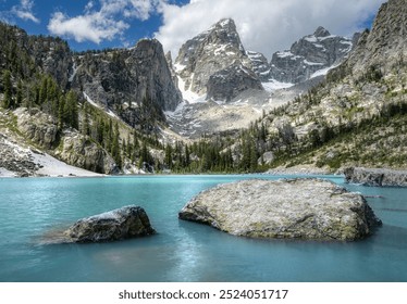 A stunning mountain landscape with clear blue skies, snowy peaks, and a turquoise lake in the foreground. - Powered by Shutterstock